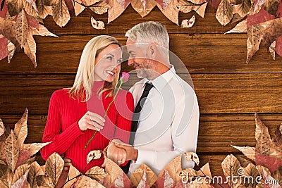 Composite image of handsome man giving his wife a pink rose Stock Photo