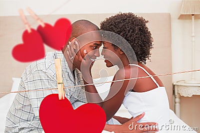 Composite image of happy couple showing affection on bed Stock Photo