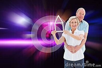 Composite image of happy older couple holding house shape Stock Photo