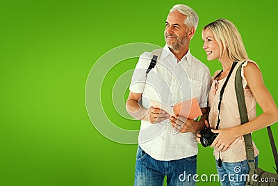 Composite image of happy tourist couple using the guidebook Stock Photo