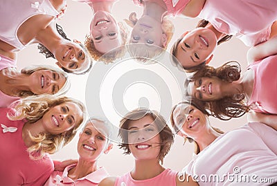 Composite image of low angle portrait of female friends supporting breast cancer Stock Photo