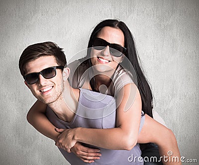 Composite image of man giving his pretty girlfriend a piggy back Stock Photo