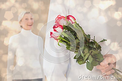 Composite image of man hiding bouquet of roses from older woman Stock Photo