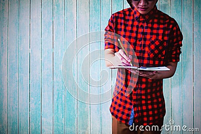 Composite image of mid section of young man writing on notebook Stock Photo