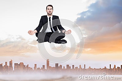 Composite image of peaceful businessman sitting in lotus pose relaxing Stock Photo