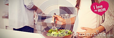 Composite image of pregnant woman mixing a salad in the kitchen Stock Photo