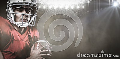 Composite image of serious american football player looking away while holding ball Stock Photo