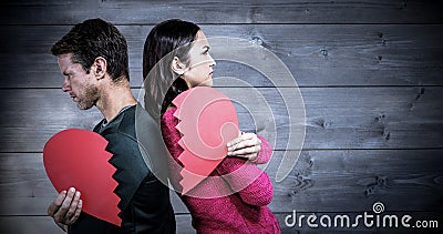 Composite image of serious couple standing back to back Stock Photo