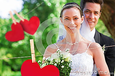 Composite image of smiling bride and groom in garden Stock Photo