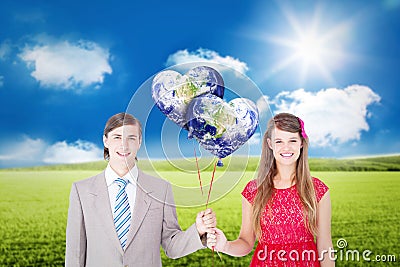 Composite image of smiling geeky couple holding red balloons Stock Photo