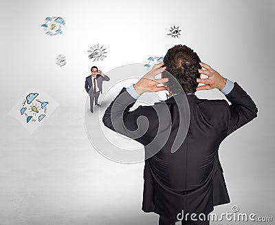 Composite image of stressed businessman with hands on head with tiny businessman Stock Photo