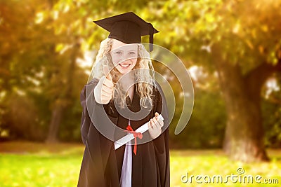 Composite image of teenage girl celebrating graduation with thumbs up Stock Photo