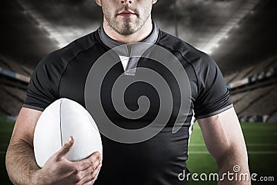 Composite image of tough rugby player holding ball Stock Photo