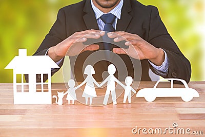 Composite image of underwriter protecting family in paper with his hands Stock Photo