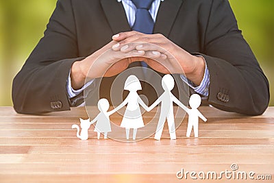 Composite image of underwriter protecting family in paper with his hands Stock Photo