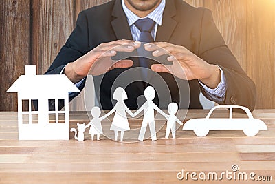 Composite image of underwriter protecting family in paper with his hands Stock Photo