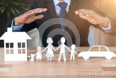 Composite image of underwriter protecting family in paper with his hands Stock Photo