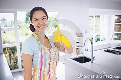 Composite image of woman in cleaning clothes giving thumbs up Stock Photo