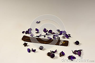 composition burning incense stick and flower petals on a white background Stock Photo