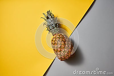 Flat lay view of tropical Pineapple fruit single on a duotone yellow-grey background Stock Photo