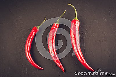 composition of chili peppe on a dark stone/red hot Chile pepper on a dark stone background. Top view Stock Photo
