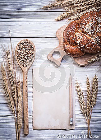 Composition of chopping board wheat-rye ears sweet baked roll wo Stock Photo