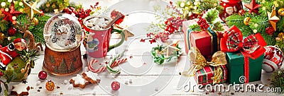 Composition with Christmas snow globe, gift boxes, cup of hot chocolate and festive decorations on wooden table. Christmas or New Stock Photo