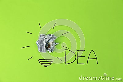 Composition with crumpled banknote, drawing of lamp bulb and word IDEA on color background. Stock Photo