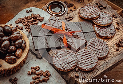 Composition of different Dark chocolate bars and pieces, Melted chocolate and Coffee beans on old wooden background Stock Photo