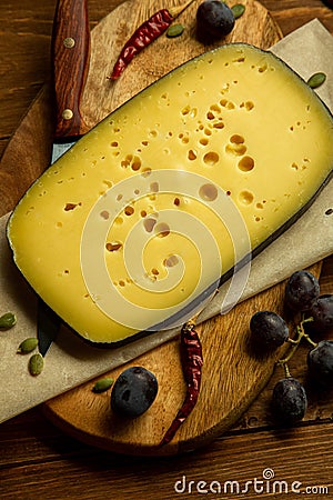 Composition of different types of sliced cheese: hard, mature, cheese with mold. Cheese slicing with fruit - grapes and figs. Stock Photo