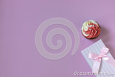 Composition with festive cupcake with pink cream and gift box on pink background. Natural light. Stock Photo