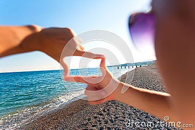 Composition finger frame- girl`s hands capture spectacular seasc Stock Photo