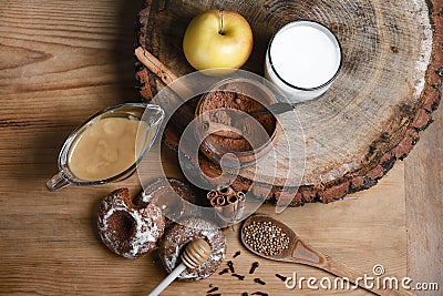 Composition gingerbreads, milk and honey and spices - cinnamon, coriander, cloves, stuffed gingerbread, apples, cocoa on a wooden Stock Photo
