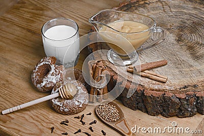 Composition gingerbreads, milk and honey and spices - cinnamon, coriander, cloves, stuffed gingerbread on a wooden background, top Stock Photo