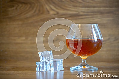 Composition with glass with delicious whiskey next to ice cubes. on oak boards Stock Photo