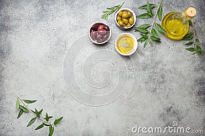 Composition with green and brown olives, extra virgin olive oil in glass bottle, olive tree branches on gray concrete Stock Photo