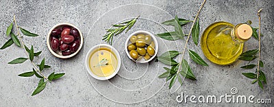 Composition with green and brown olives, extra virgin olive oil in glass bottle, olive tree branches on gray concrete Stock Photo