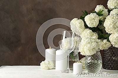 Composition hydrangea flowers and candles against brown background. Romantic evening Stock Photo