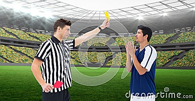 Composition of male referee holding yellow card and player at football stadium Stock Photo