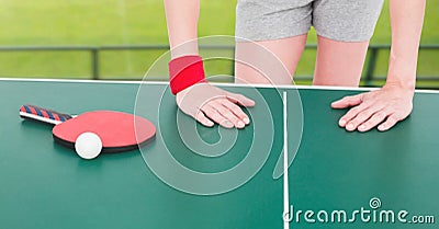 Composition of mid section of female table tennis player leaning on table with ball and racket Stock Photo