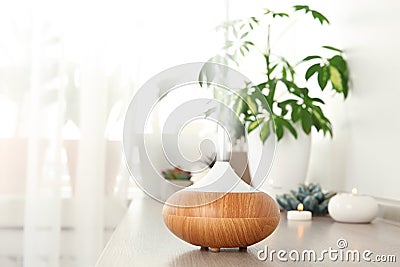 Composition with modern essential oil diffuser on wooden shelf indoors Stock Photo