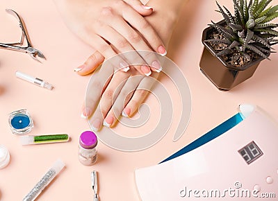 Composition for nail care, female young hands, French manicure, gel polish, lamp for nails and equipment for nail care. Flat lay Stock Photo