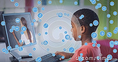 Composition of network of icons over female teacher and schoolboy on laptop online lesson Stock Photo