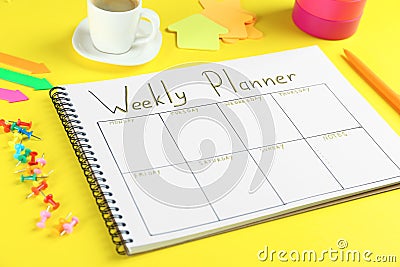 Composition of notebook with weekly plan on yellow background Stock Photo