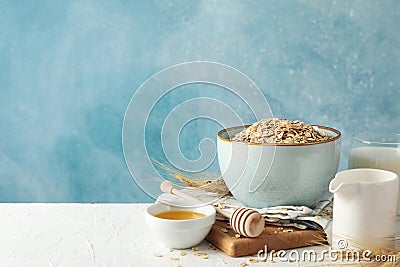 Composition oatmeal flakes and milk on white table. Cooking breakfast Stock Photo