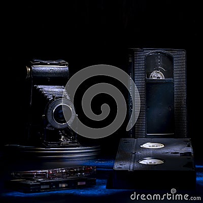 Composition of old vhs cassettes, cassette tapes and an antique bellows camera Stock Photo