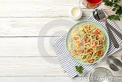 Composition with plate tasty pasta with shrimps on wooden background Stock Photo