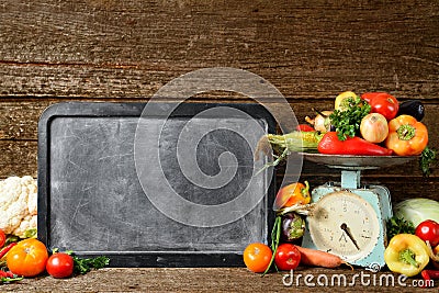 Composition of raw organic fresh vegetables, chalk board for texton, balance on wooden brown table Stock Photo