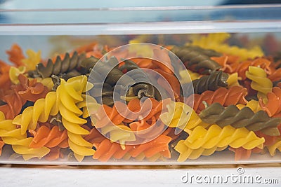 Composition of raw pasta uncooked tricolore fusilli, pasta twist shape. Close up and selective focus on colorful fusilli pasta Stock Photo