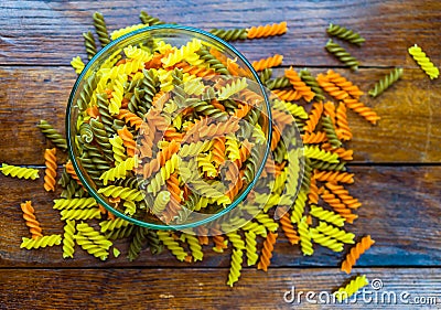 Composition of raw pasta uncooked tricolore fusilli, pasta twist shape. Close up and selective focus on colorful fusilli pasta. Stock Photo